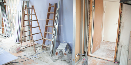 Billedet viser et hus under ombygning - rå vægge , stiger, maling 