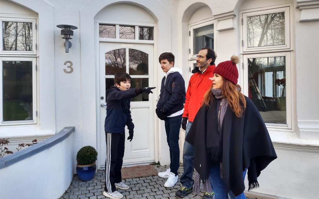 Family standing next to a house