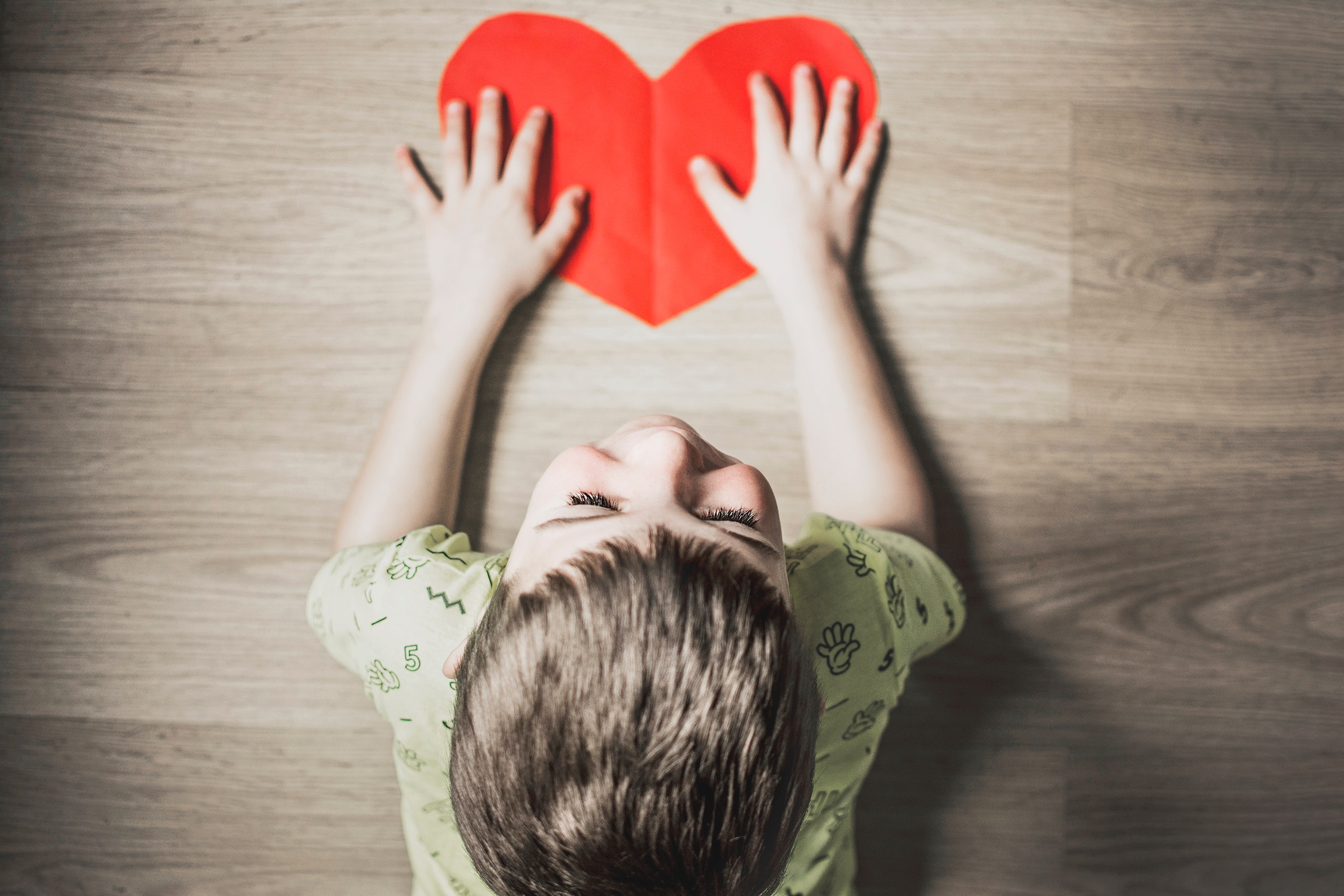 Child with red paper heart