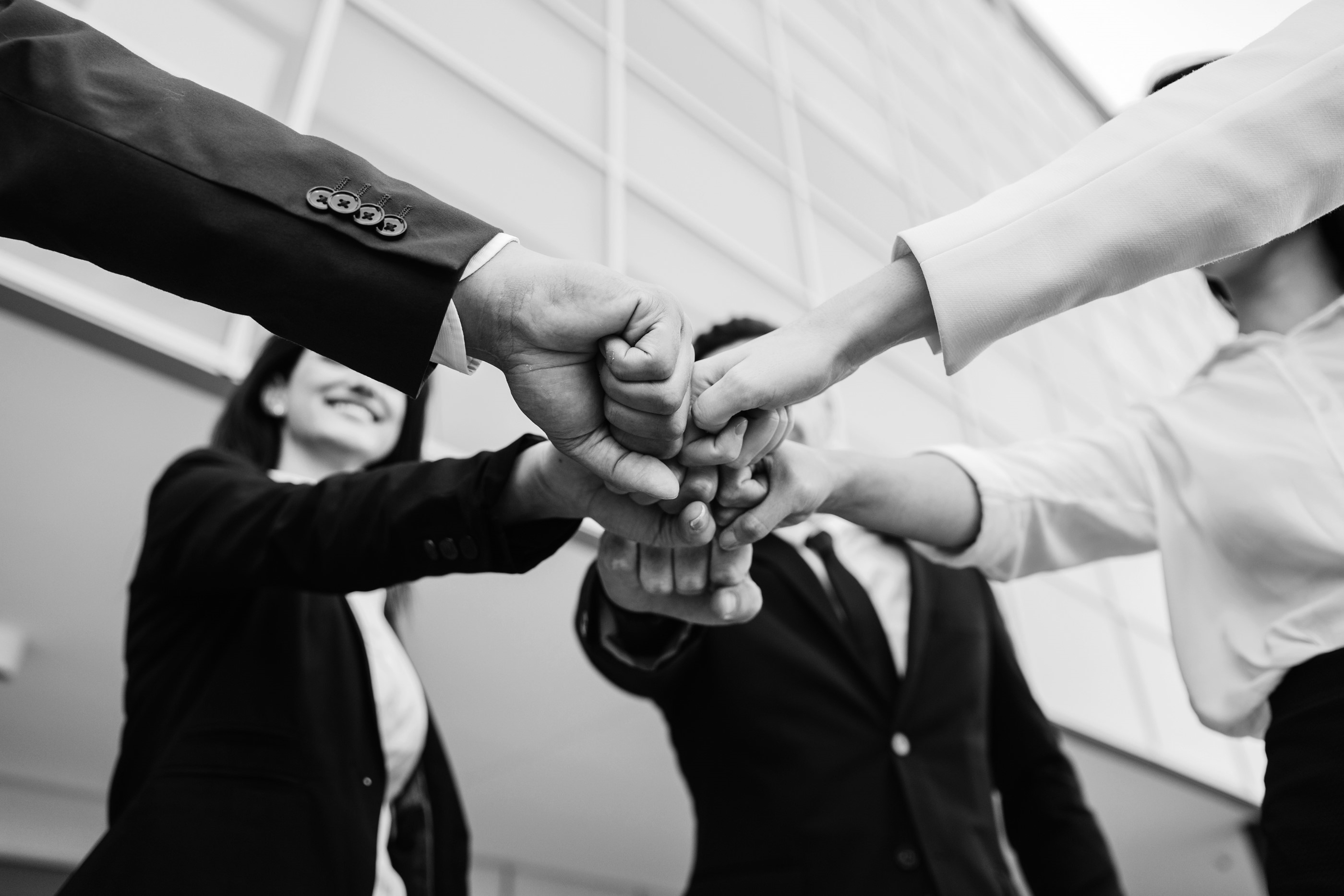 Knyttet hænder der samles i midten 